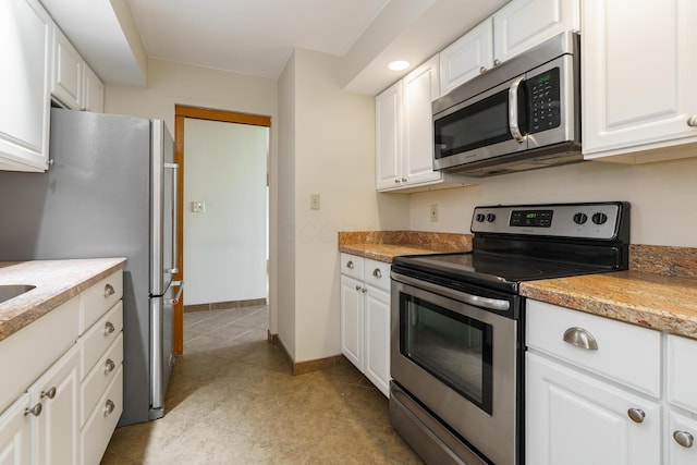1000 Urlin Ave Unit 1407, Columbus, OH 43212 - kitchen featuring baseboards, light tile patterned floors, white cabinets, and stainless steel appliances