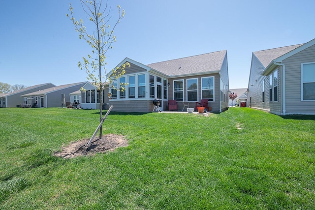 rear view of house with a sunroom and a yard