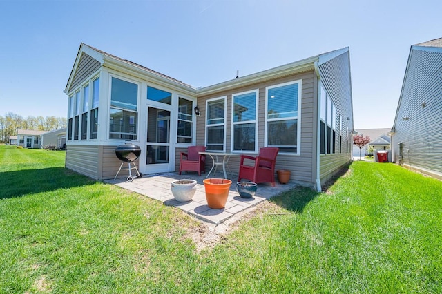 back of house with a lawn and a patio