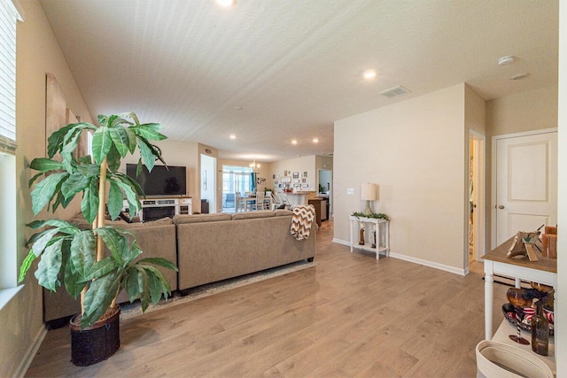 living area featuring visible vents, recessed lighting, light wood finished floors, and baseboards