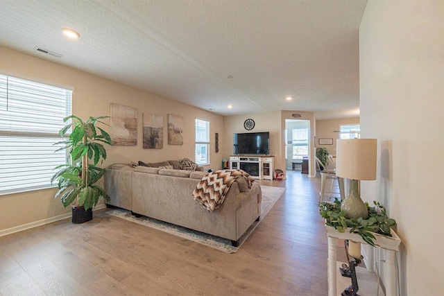 living room with baseboards, recessed lighting, light wood-style flooring, and visible vents