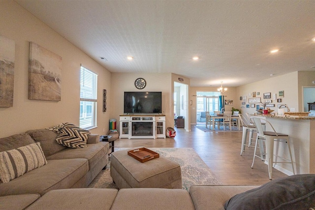 living area featuring recessed lighting, a chandelier, visible vents, and light wood-type flooring