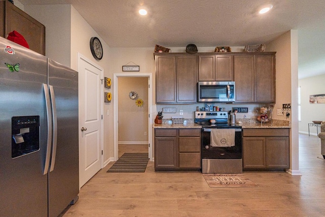 kitchen featuring stainless steel appliances, baseboards, recessed lighting, and light wood-style floors