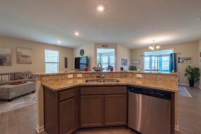 kitchen with wood finished floors, open floor plan, a sink, and dishwasher
