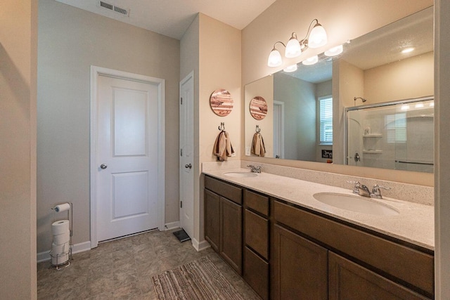 bathroom featuring baseboards, visible vents, a shower stall, and a sink