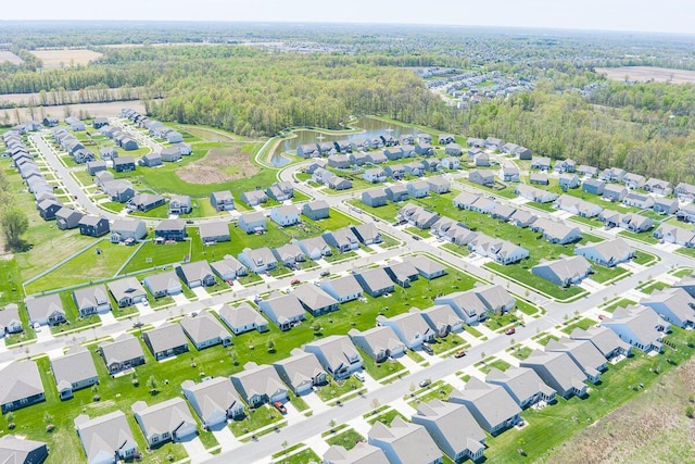 birds eye view of property featuring a water view, a residential view, and a wooded view