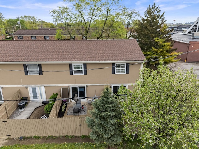 back of house featuring fence, stucco siding, and central AC