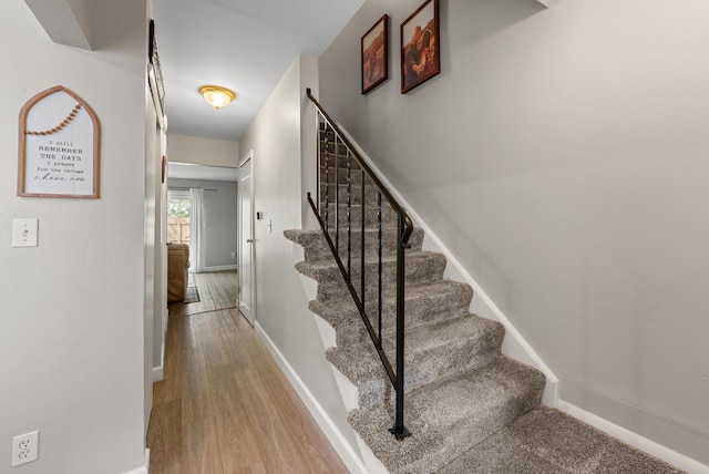 stairs with baseboards and wood finished floors
