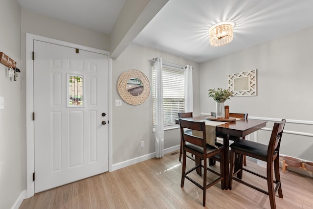 dining room featuring baseboards, a notable chandelier, and light wood-style floors