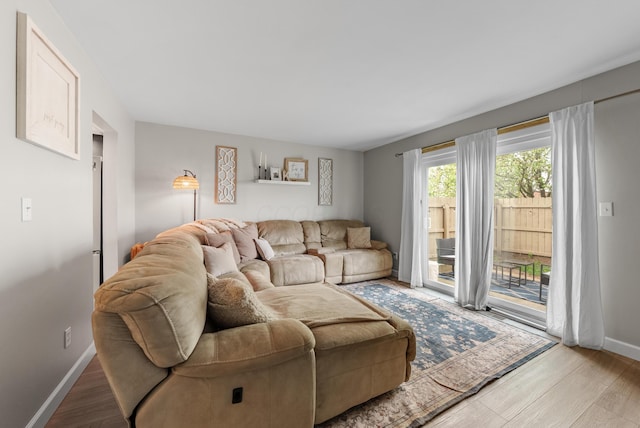 living area with baseboards and wood finished floors