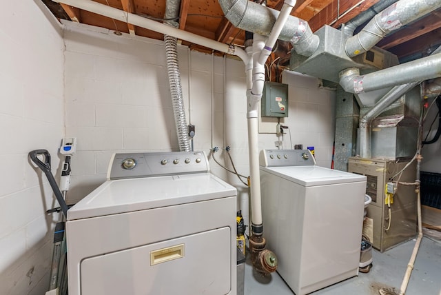 washroom with laundry area, heating unit, independent washer and dryer, and concrete block wall