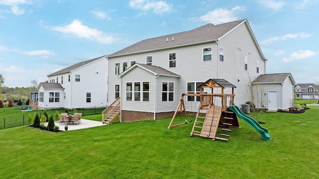 back of property with a yard, a patio, fence, and a playground