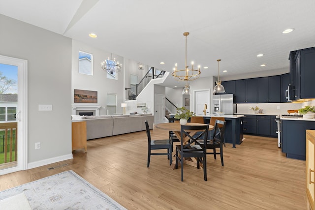 dining space with an inviting chandelier, light wood-style flooring, and a wealth of natural light