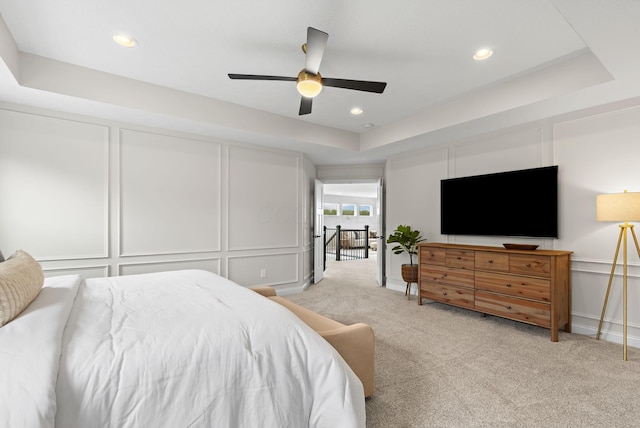 bedroom with ceiling fan, a decorative wall, recessed lighting, and light colored carpet