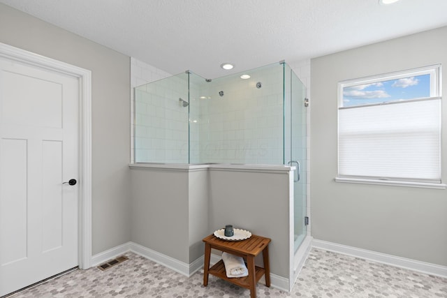 full bathroom with a textured ceiling, visible vents, a stall shower, baseboards, and recessed lighting