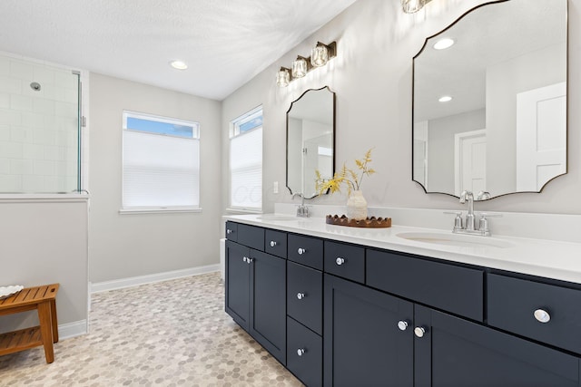 full bathroom with double vanity, walk in shower, a sink, and recessed lighting