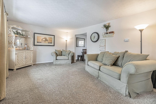 living room featuring carpet flooring, a textured ceiling, and baseboards