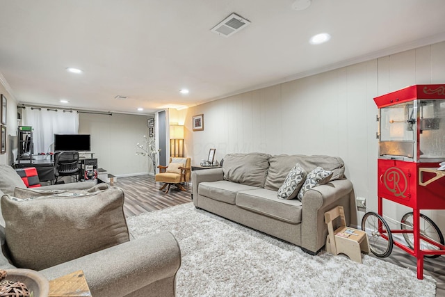 living area featuring visible vents, recessed lighting, crown molding, and wood finished floors