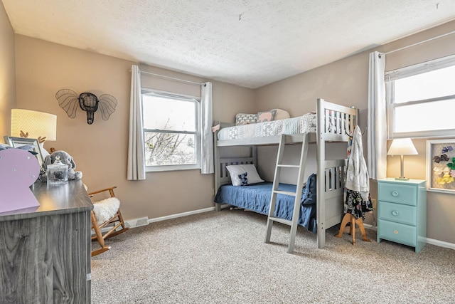 bedroom featuring a textured ceiling, light colored carpet, and baseboards