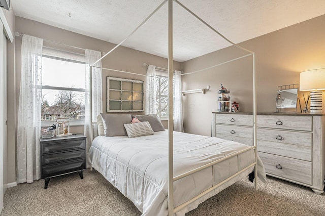 bedroom featuring light carpet and a textured ceiling