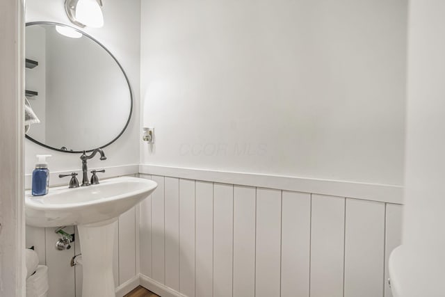 half bathroom featuring wainscoting