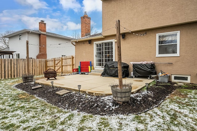 rear view of property with fence, an outdoor fire pit, a patio, entry steps, and stucco siding