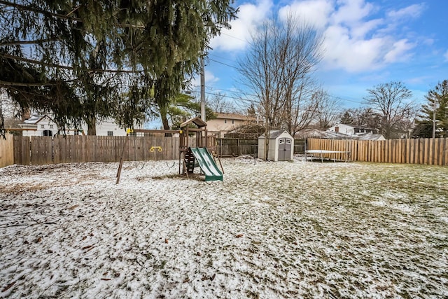 view of yard featuring a playground, an outbuilding, a fenced backyard, and a shed