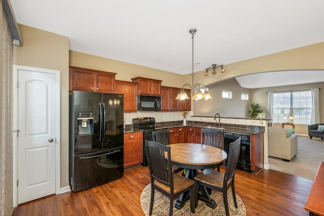 dining room with baseboards, arched walkways, and dark wood finished floors