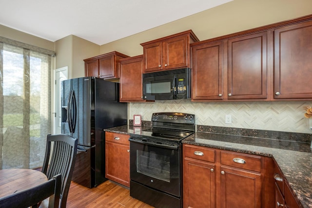kitchen with backsplash, black appliances, dark stone countertops, and light wood-style flooring