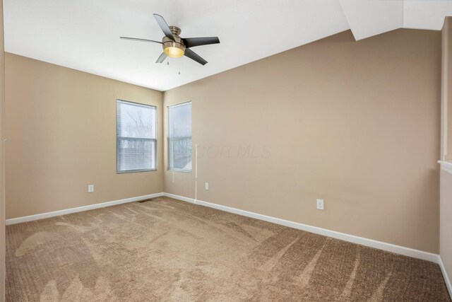 spare room with a ceiling fan, baseboards, and carpet