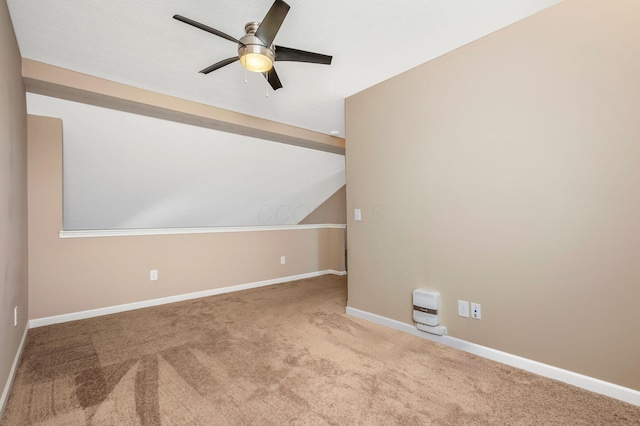 carpeted spare room featuring baseboards, a ceiling fan, and lofted ceiling