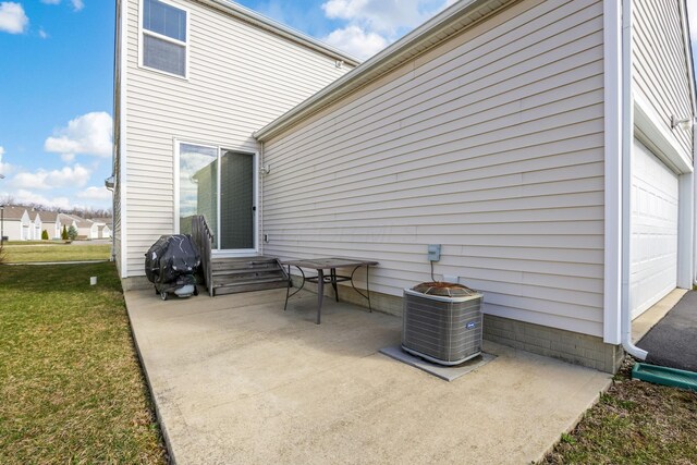 view of patio with central air condition unit and a garage