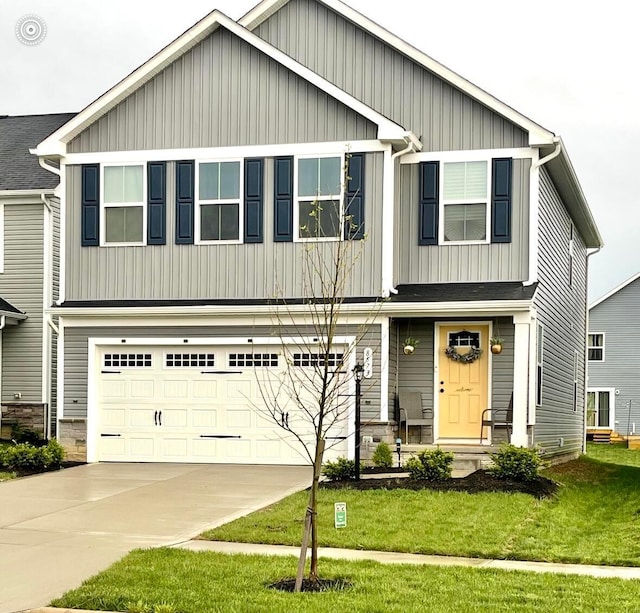 craftsman inspired home featuring stone siding, a garage, board and batten siding, a front yard, and concrete driveway