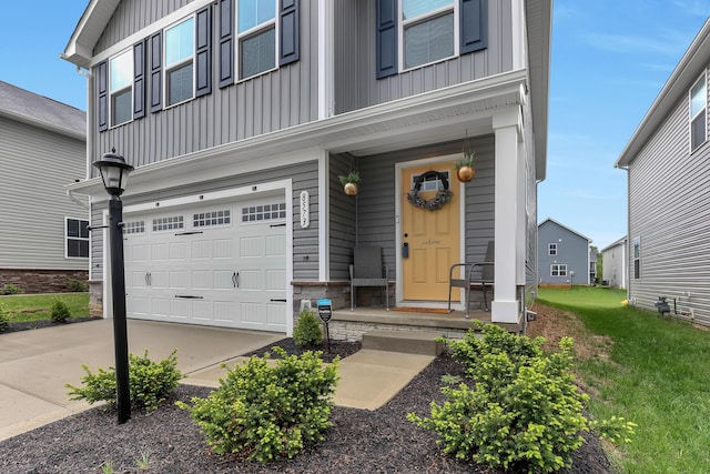 8573 Greengate Blvd Unit 41, Canal Winchester, OH 43110 - view of exterior entry with board and batten siding, driveway, and a garage