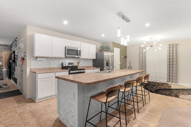 8573 Greengate Blvd Unit 41, Canal Winchester, OH 43110 - kitchen featuring a sink, a kitchen island with sink, white cabinets, and stainless steel appliances
