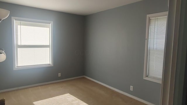 carpeted empty room with baseboards