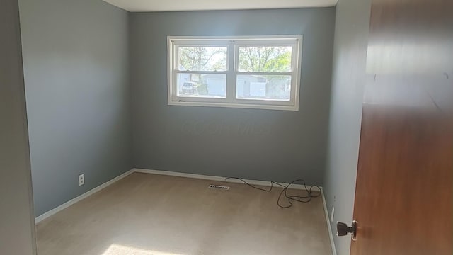 carpeted empty room with baseboards and visible vents