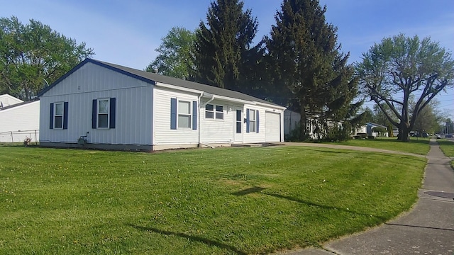 manufactured / mobile home with an attached garage and a front yard