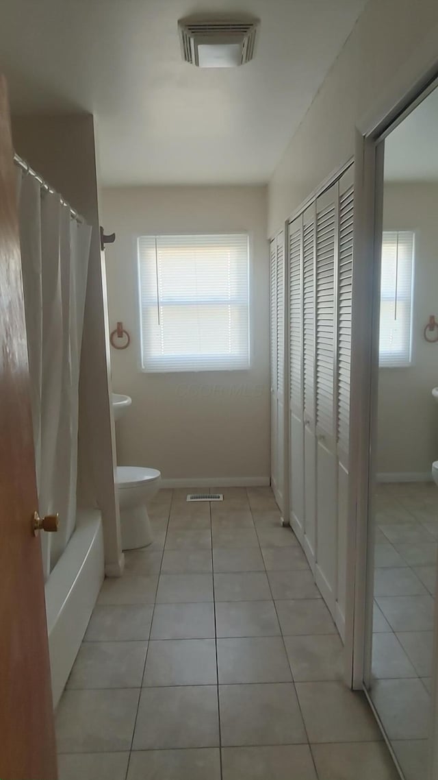 bathroom featuring plenty of natural light, tile patterned floors, visible vents, and toilet