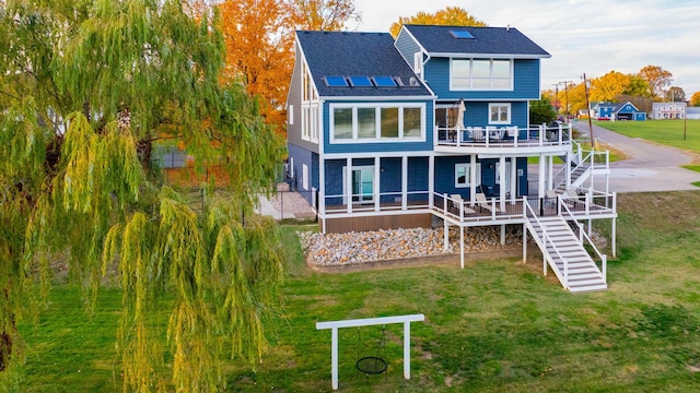301 John St, Belpre, OH 45714 - rear view of property featuring stairs, a lawn, a wooden deck, and roof with shingles