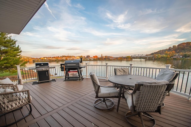 301 John St, Belpre, OH 45714 - deck at dusk with a water view, outdoor dining area, and a grill