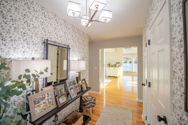 301 John St, Belpre, OH 45714 - corridor with baseboards, wood finished floors, a chandelier, and wallpapered walls