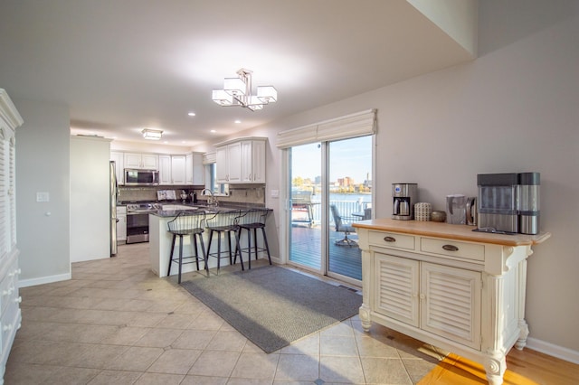 301 John St, Belpre, OH 45714 - kitchen featuring a sink, a breakfast bar area, stainless steel appliances, baseboards, and a peninsula