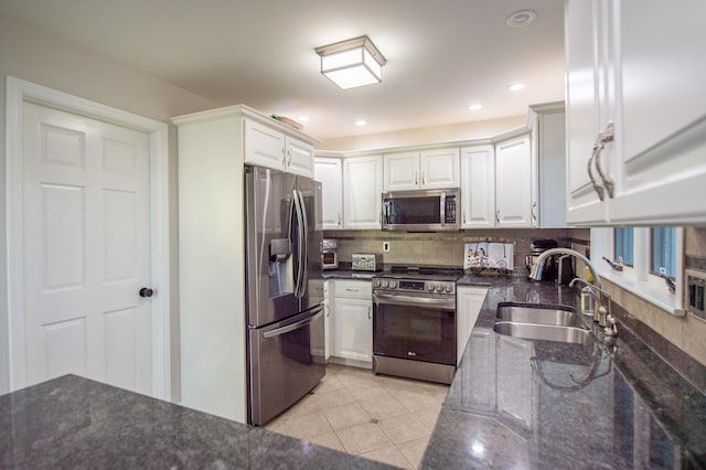 301 John St, Belpre, OH 45714 - kitchen featuring white cabinets, appliances with stainless steel finishes, decorative backsplash, and a sink