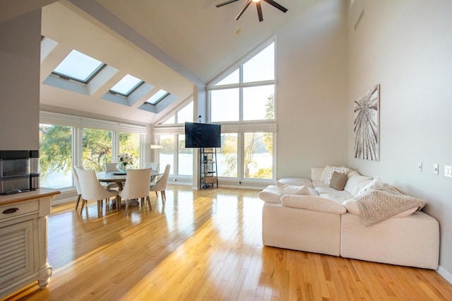 301 John St, Belpre, OH 45714 - living room featuring a skylight, high vaulted ceiling, ceiling fan, and light wood-style flooring