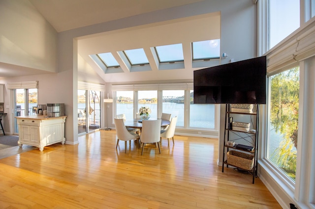 301 John St, Belpre, OH 45714 - dining space with light wood-type flooring, plenty of natural light, a skylight, and high vaulted ceiling