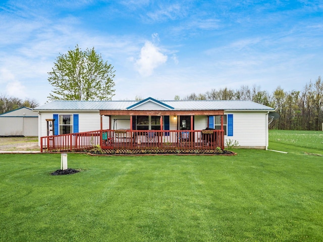 back of property with a lawn, metal roof, and covered porch