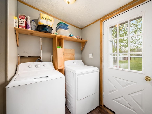 clothes washing area featuring laundry area, a textured ceiling, ornamental molding, dark wood-style floors, and washer and clothes dryer