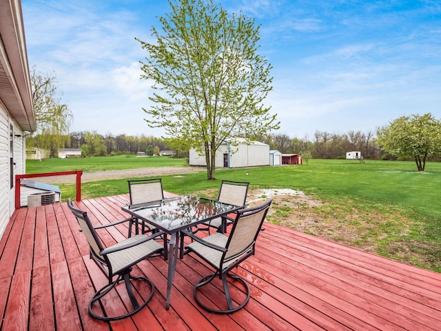 wooden deck with a yard, an outbuilding, and outdoor dining area