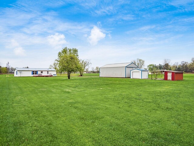 view of yard featuring a garage, an outbuilding, and a pole building